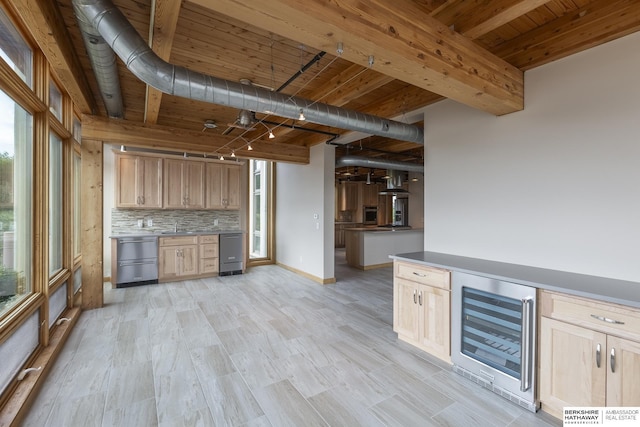 kitchen featuring plenty of natural light, backsplash, beverage cooler, and light brown cabinets