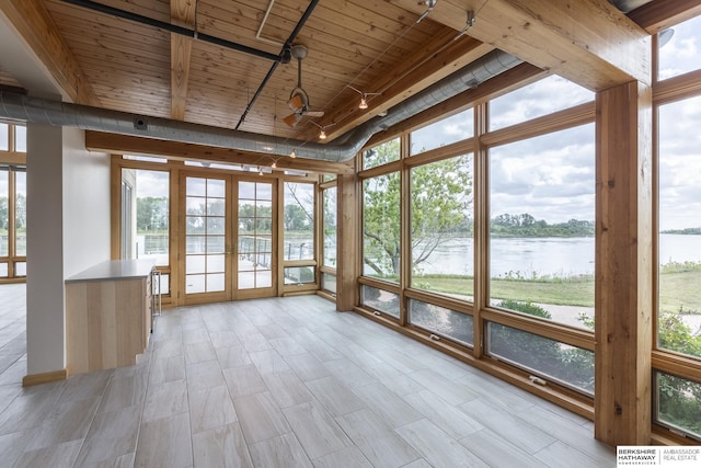 unfurnished sunroom with a ceiling fan, track lighting, french doors, a water view, and wooden ceiling