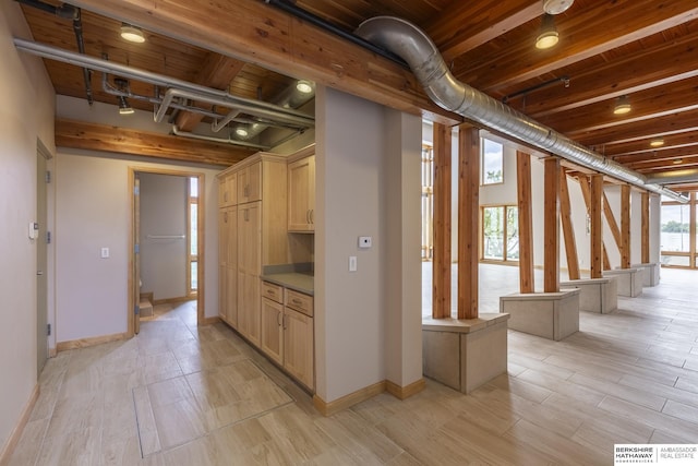 interior space with beamed ceiling, baseboards, wood ceiling, and track lighting