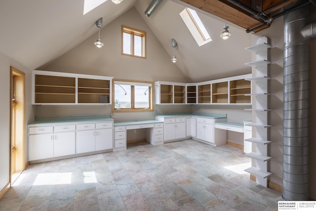 kitchen featuring open shelves, a wealth of natural light, a skylight, and white cabinetry