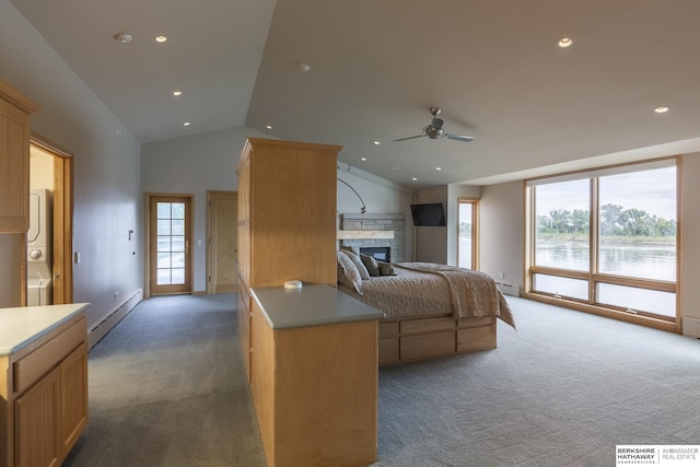 bedroom with light carpet, a fireplace, stacked washer / drying machine, baseboard heating, and vaulted ceiling