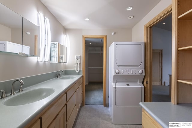 interior space featuring laundry area, recessed lighting, stacked washer and clothes dryer, and a sink