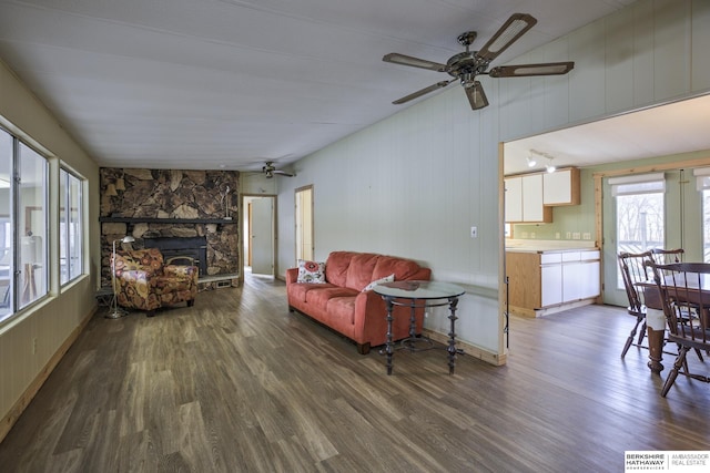 living room with a ceiling fan, wood finished floors, and a fireplace