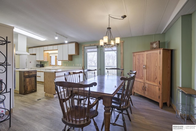 dining area with a notable chandelier and light wood finished floors