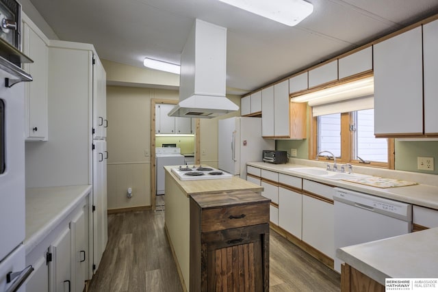 kitchen with white appliances, washer / clothes dryer, island exhaust hood, a sink, and dark wood-type flooring