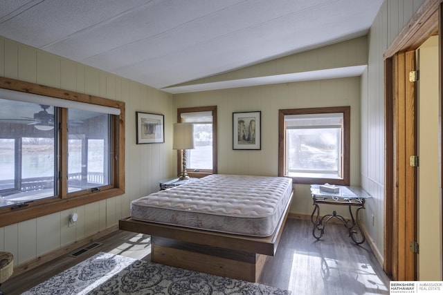 bedroom with vaulted ceiling, baseboards, visible vents, and light wood finished floors