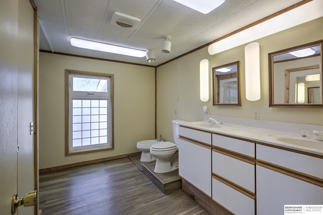 full bath with a sink, toilet, wood finished floors, and double vanity