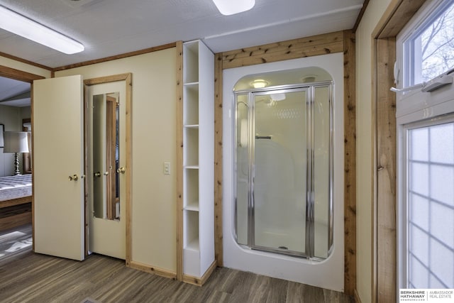 full bath with plenty of natural light, a stall shower, and wood finished floors