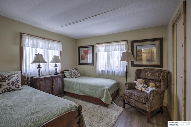 bedroom featuring multiple windows and wood finished floors