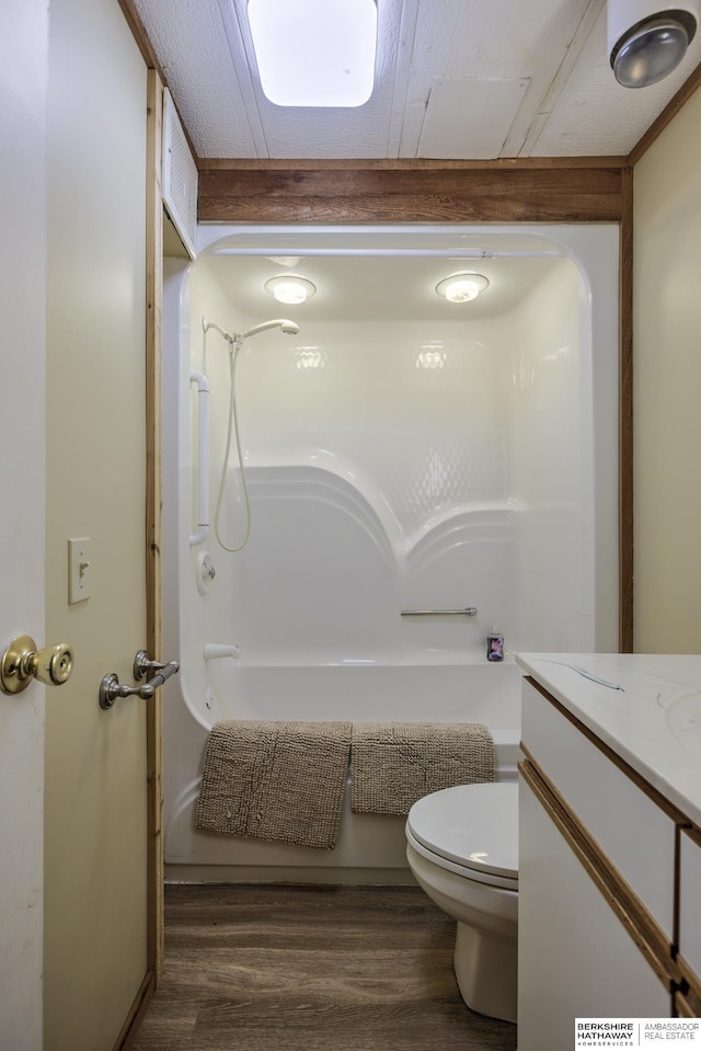 bathroom with toilet, wood finished floors, and washtub / shower combination