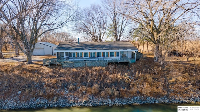 back of house featuring a wooden deck, an outbuilding, and a garage