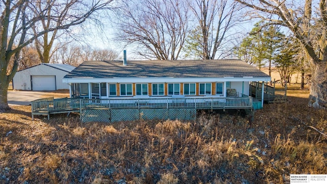 view of front of home with a detached garage and an outbuilding