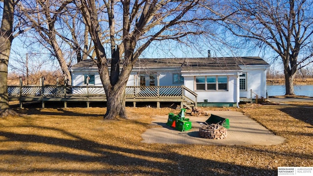 back of property featuring a deck with water view