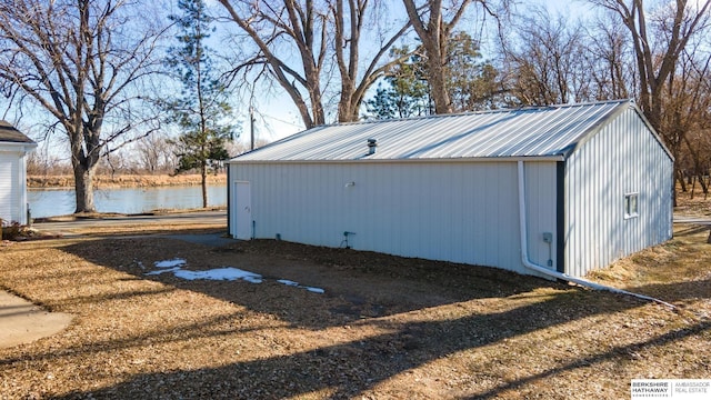 view of outdoor structure with a water view and an outbuilding