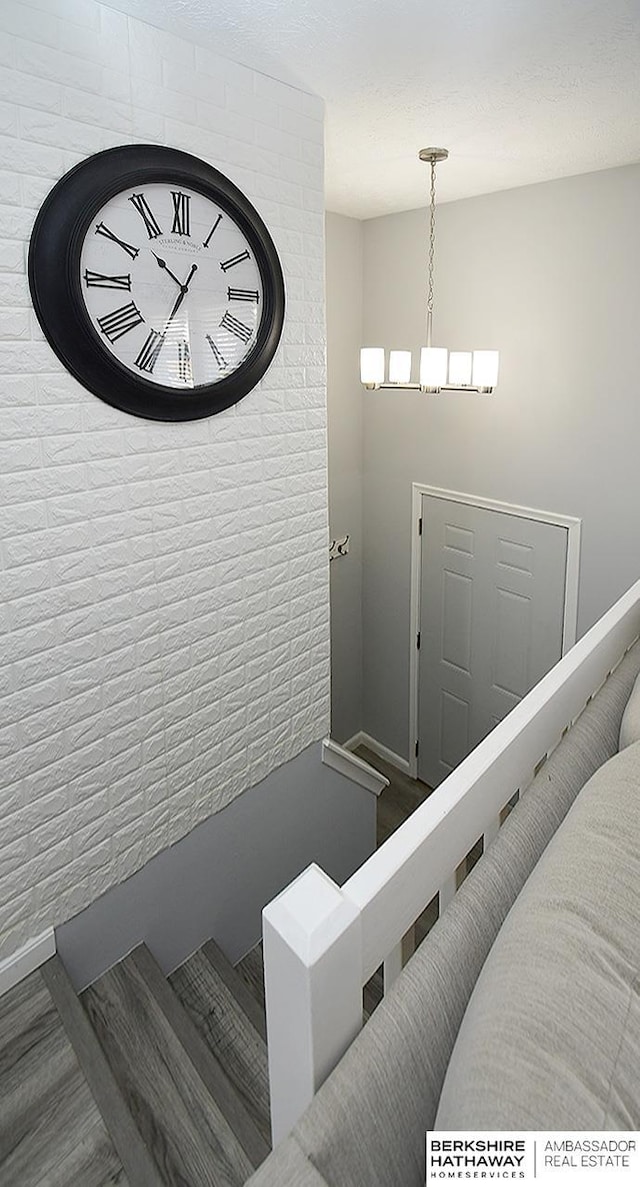 staircase featuring an inviting chandelier, wood finished floors, and baseboards