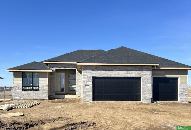 view of front of house featuring a garage, roof with shingles, and stone siding