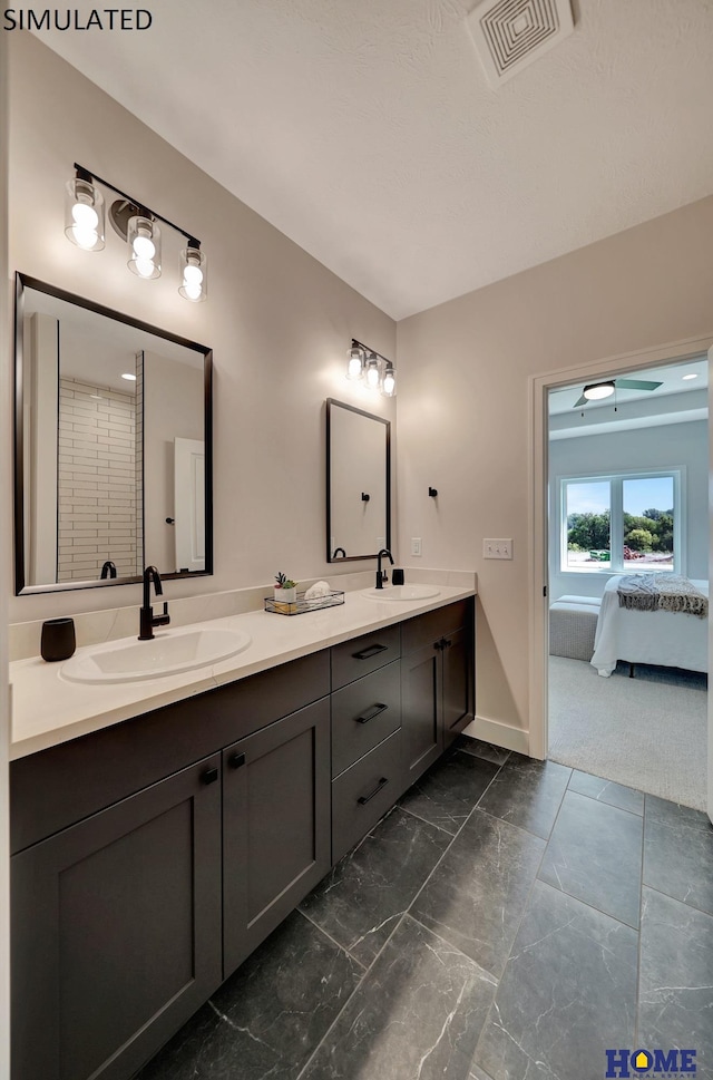 ensuite bathroom featuring a sink, visible vents, connected bathroom, and double vanity