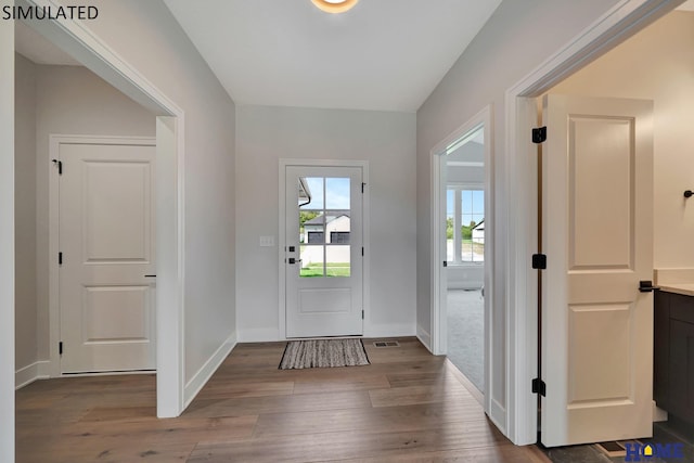 entryway with visible vents, wood finished floors, and baseboards