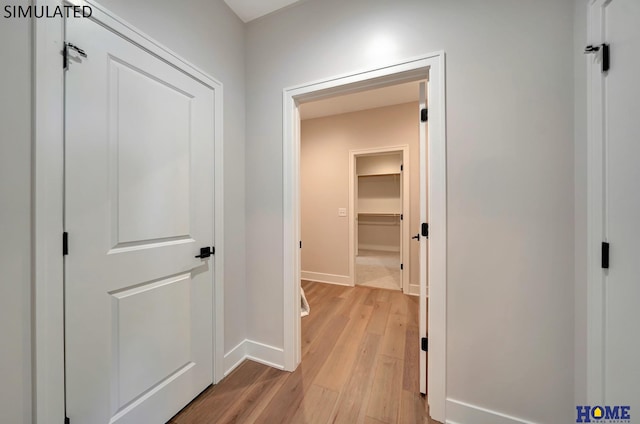 hall featuring baseboards and light wood-style flooring