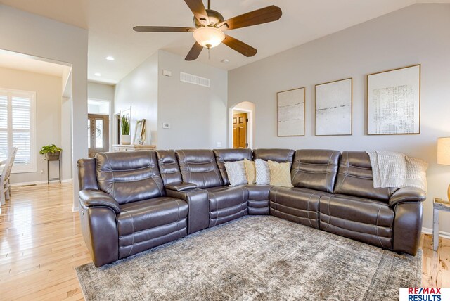 living room featuring visible vents, light wood-style flooring, recessed lighting, arched walkways, and baseboards