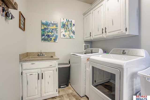 washroom featuring cabinet space, washer and dryer, and a sink