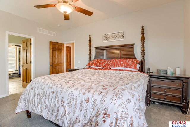 bedroom featuring ensuite bath, a ceiling fan, visible vents, and carpet floors