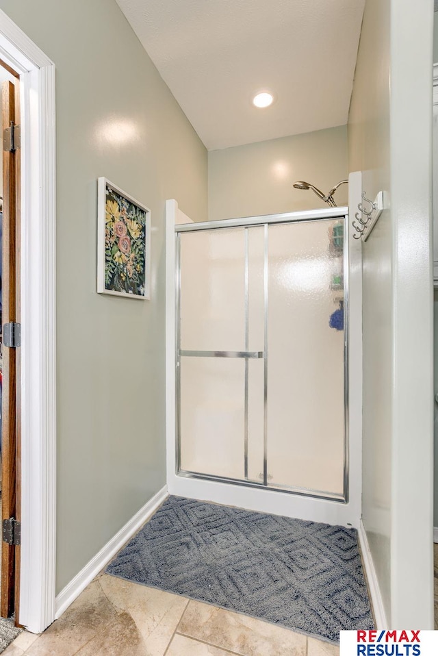 bathroom featuring baseboards and a stall shower