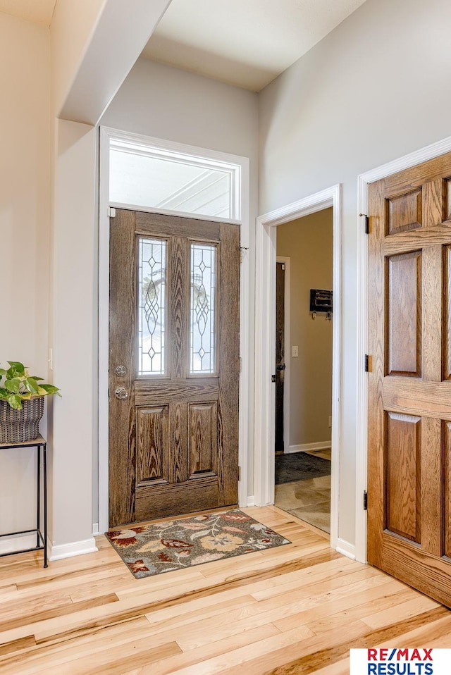 foyer entrance featuring baseboards and wood finished floors