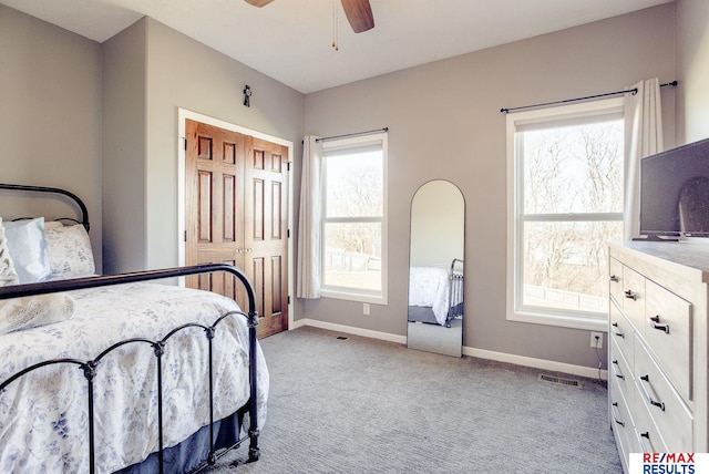 carpeted bedroom featuring visible vents, a ceiling fan, and baseboards