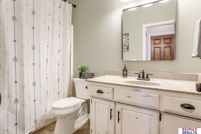 bathroom featuring curtained shower, toilet, vanity, and tile patterned flooring