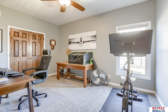 office space with baseboards, carpet, and a ceiling fan