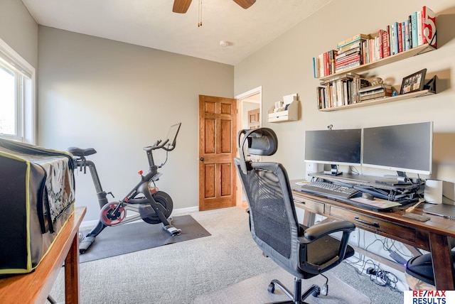 carpeted office with baseboards and a ceiling fan