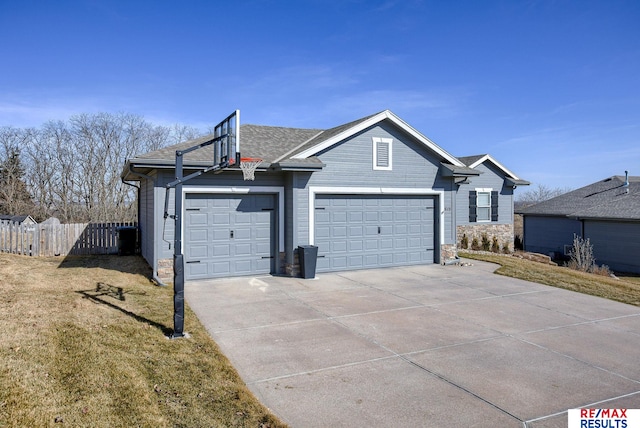 view of front of home featuring stone siding, fence, concrete driveway, a front yard, and an attached garage