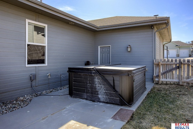 view of patio featuring fence and a hot tub