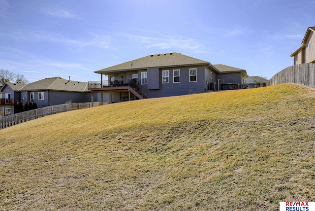 rear view of property with stairway, a yard, central AC, a deck, and fence private yard