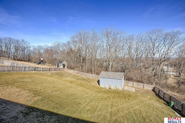 view of yard featuring a storage shed, an outdoor structure, and a fenced backyard