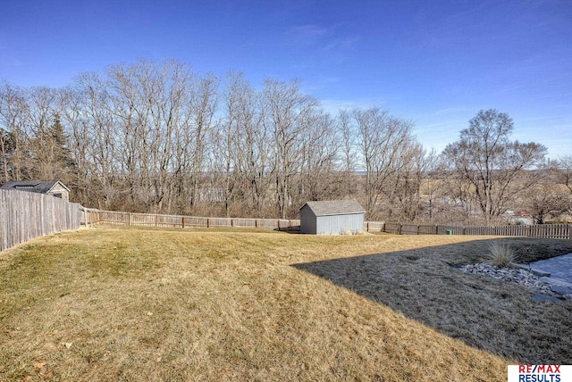 view of yard with a storage shed, an outbuilding, and a fenced backyard