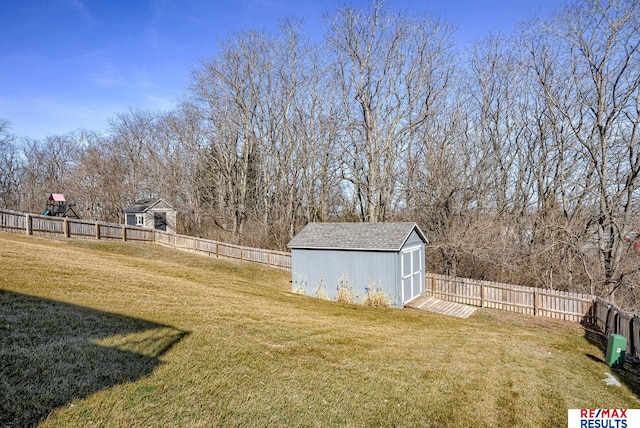 view of yard with an outbuilding, a storage shed, and a fenced backyard