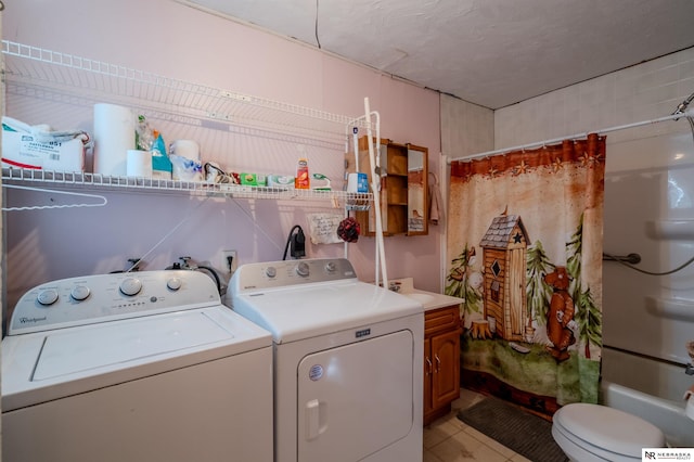 laundry area with laundry area, light tile patterned flooring, and washing machine and dryer