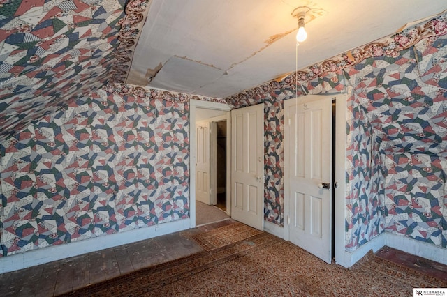 unfurnished room featuring wallpapered walls