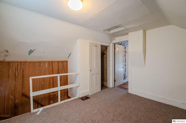 additional living space featuring lofted ceiling, attic access, carpet, and visible vents