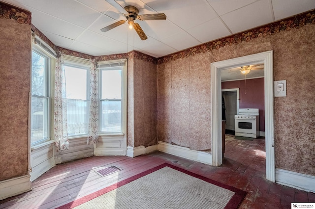 spare room featuring visible vents, ceiling fan, baseboards, and hardwood / wood-style floors