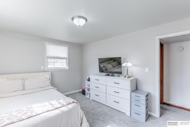 bedroom featuring light colored carpet and baseboards