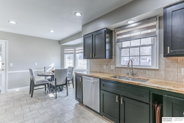 kitchen featuring dishwasher, light stone countertops, backsplash, and a sink