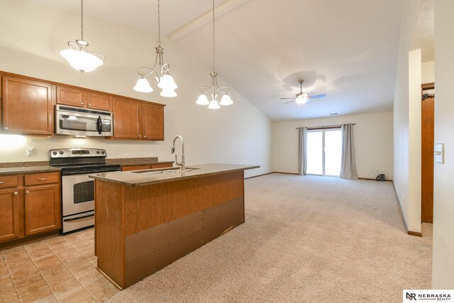 kitchen with light colored carpet, brown cabinets, appliances with stainless steel finishes, and a sink