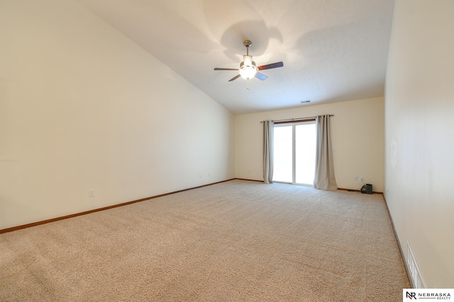 spare room with visible vents, baseboards, light colored carpet, ceiling fan, and vaulted ceiling