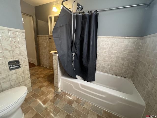 full bath with a wainscoted wall, toilet, tile walls, and shower / bathtub combination with curtain