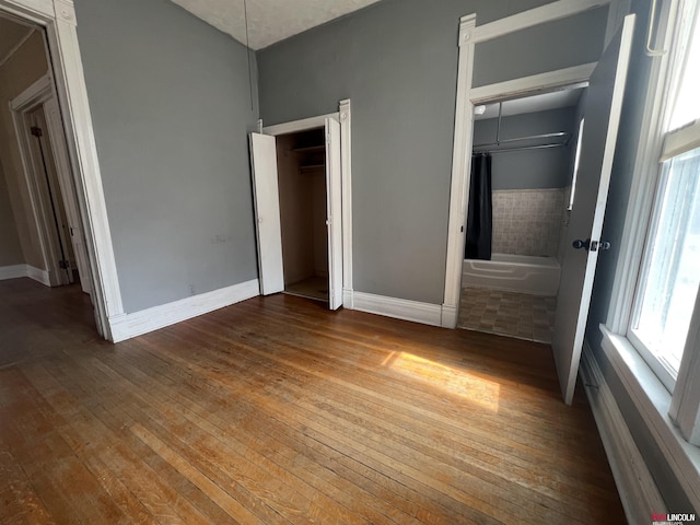 unfurnished bedroom with baseboards and wood-type flooring