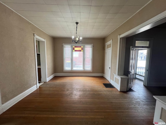 unfurnished dining area featuring an inviting chandelier, dark wood-type flooring, a healthy amount of sunlight, and baseboards