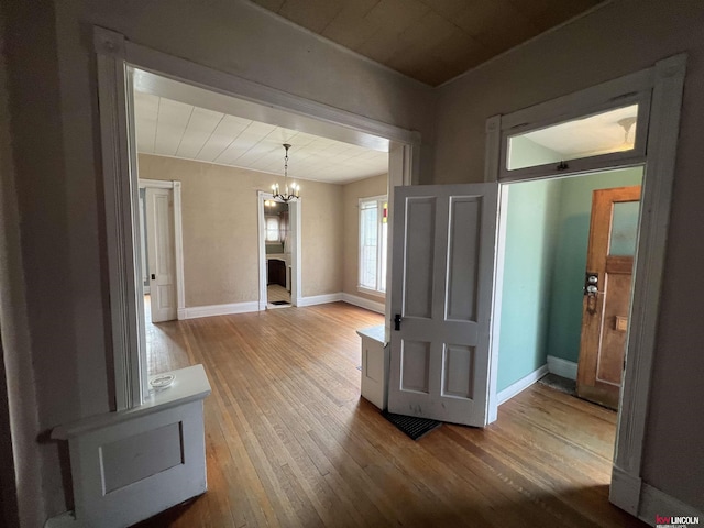 interior space featuring a chandelier, baseboards, and hardwood / wood-style floors